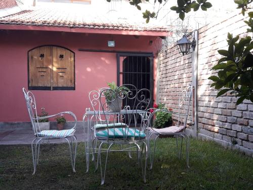 three chairs and a table in front of a house at The Blue Room in Mendoza