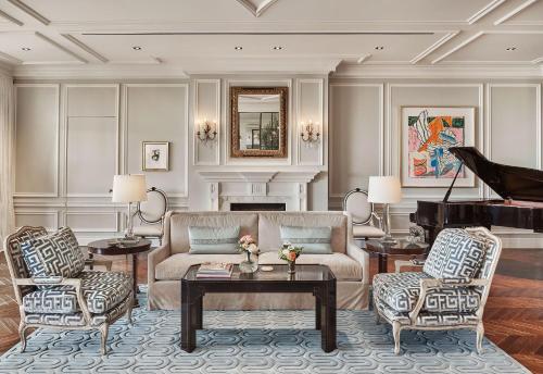 a living room with a couch and a piano at Rosewood Miramar Beach in Santa Barbara