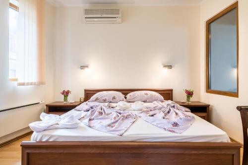 a bedroom with a bed with white sheets and a window at Sozopol Seaside Villa in Sozopol