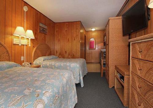 a hotel room with two beds and a flat screen tv at The Skylark Beach Inn in Old Orchard Beach