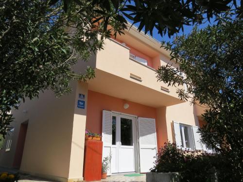 a house with orange and white at Apartment and Rooms Amenka in Novalja