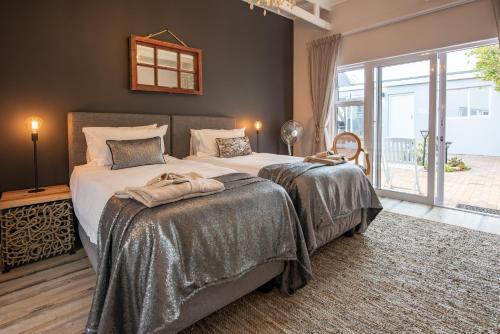 una camera con due letti e una grande finestra di SALT Boutique Guesthouse a Bloubergstrand