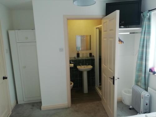 een witte badkamer met een wastafel en een toilet bij Slaney House B&B in Lahinch