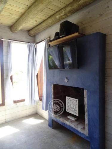 a fireplace in a room with a blue wall at Casas Sadhana in Punta Del Diablo