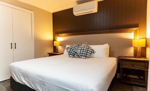 um quarto com uma cama grande com duas almofadas em Nightcap at Archer Hotel em Nowra