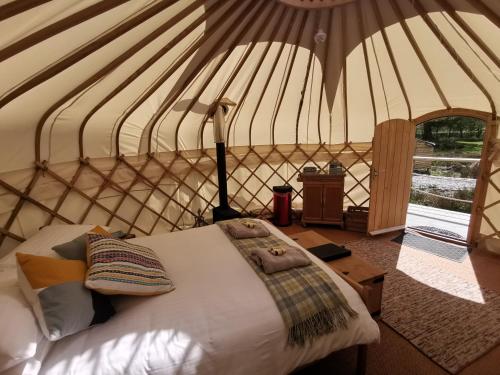 a bedroom with a bed in a yurt at Syke Farm Campsite - Yurt's and Shepherds Hut in Buttermere