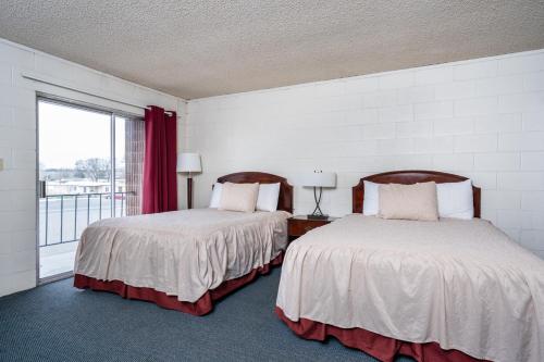 two beds in a room with a window at M&M Motel in Connell