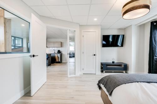 een slaapkamer met een bed en uitzicht op een keuken bij Complexe La Voûte by KASANIA - Condo 201 in Laval