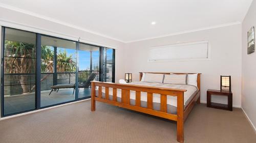 a bedroom with a bed and a balcony at KK's in Lennox Head