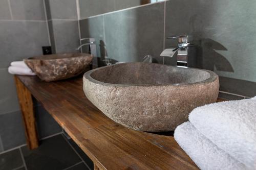 a bathroom with two stone sinks on a wooden counter at Jazz ArT's Penthouse in Olpenitz