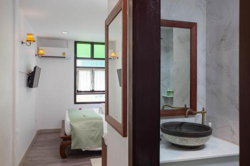 a bathroom with a sink and a mirror at Sound Gallery House - SHA Plus in Phuket