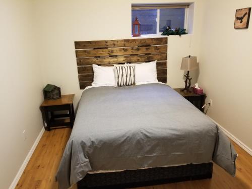 Schlafzimmer mit einem großen Bett mit einem Kopfteil aus Holz in der Unterkunft Roche Bonhomme Rustic Suite in Jasper