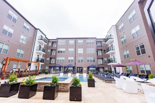 un patio del hotel con piscina, sillas y edificios en Kasa Forest Park St Louis en Maryland Heights