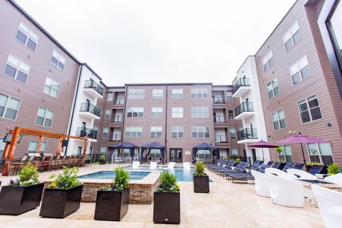 a hotel courtyard with a pool and chairs and buildings at Kasa Forest Park St Louis in Maryland Heights