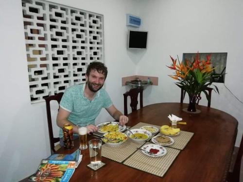 a man sitting at a table with a plate of food at Old Parkland Hostel in Galle