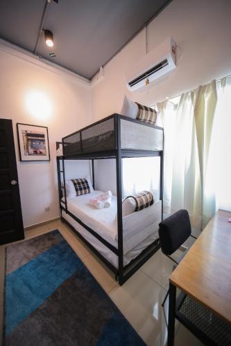 a room with two bunk beds and a table at The Best Hotel in Bayan Lepas - THE LOV PENANG in Bayan Lepas