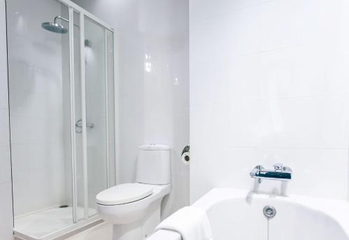 a white bathroom with a toilet and a shower at Grand Howard Hotel Bangkok in Bangkok