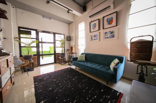 a living room with a blue couch and a rug at The Best Hotel in Bayan Lepas - THE LOV PENANG in Bayan Lepas
