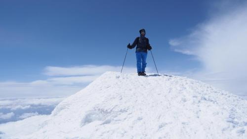 Un uomo in piedi sopra un cumulo di neve di Butik Ertur Hotel a Doğubayazıt