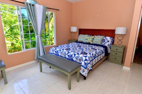 sypialnia z łóżkiem i oknem w obiekcie Takuma Boutque Hotel Hotel Rooms & Suites w mieście Montego Bay