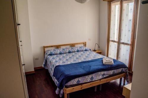 een slaapkamer met een bed met een blauw dekbed bij New A Casa da Ida in Parma
