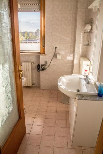 a bathroom with a sink and a toilet and a window at FuoriPorta Affitti Brevi - New A Casa da Ida in Parma