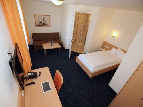 a hotel room with a bed and a desk at Hotel Gasthof Schützen GbR in Laupheim