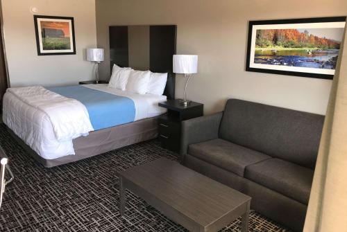 a hotel room with a bed and a couch at Days Inn by Wyndham Grove in Grove