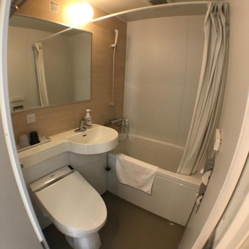 a bathroom with a toilet and a sink and a tub at Frame Hotel Sapporo in Sapporo