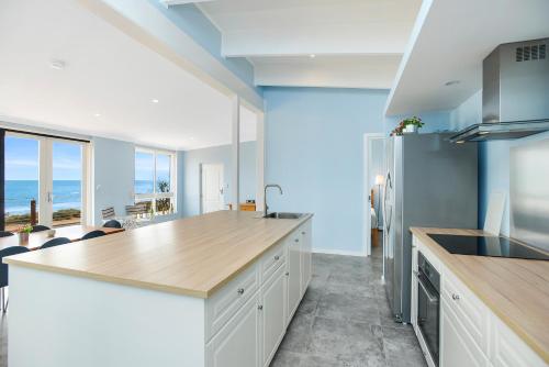 a kitchen with white cabinets and a wooden counter top at Salomon Sea Haus - Sellicks Beach - C21 SouthCoast Holidays in Sellicks Beach