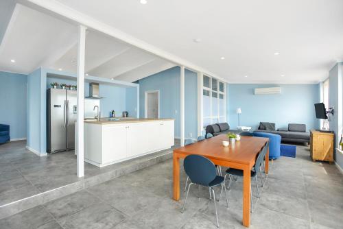 a living room with a table and a kitchen at Salomon Sea Haus - Sellicks Beach - C21 SouthCoast Holidays in Sellicks Beach