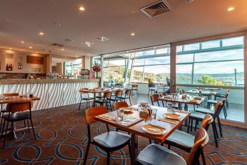 LindisfarneにあるBeltana Hotelのテーブルと椅子とバーのあるレストラン