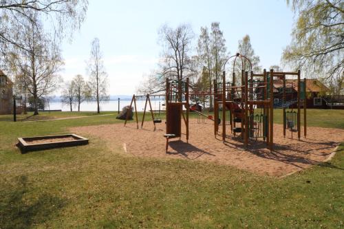 un parque con parque infantil con columpios en Stiftsgården i Rättvik, en Rättvik