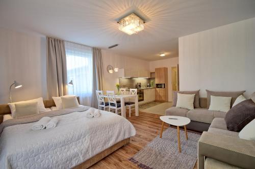 a bedroom with a bed and a couch and a table at Bliżej Morza 16 PREMIUM in Kołobrzeg