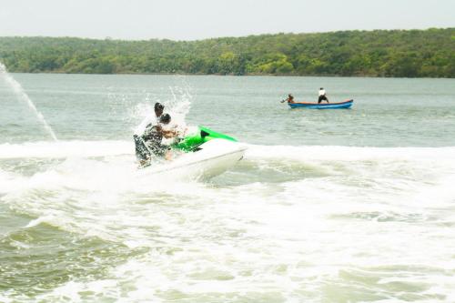 a man riding on a boat in the water at Athaang Beach Resort in Malvan