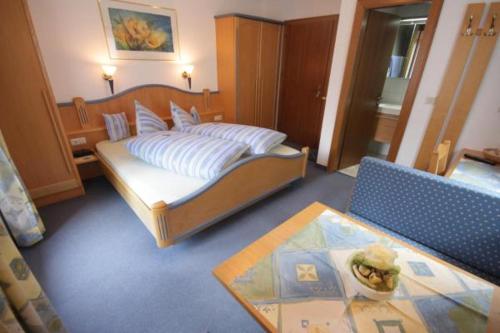 マイヤーホーフェンにあるGästehaus Waldruhのベッドルーム(ベッド1台、テーブル付)