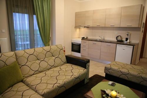 a living room with a couch and a kitchen at Mouses Apartments in Kastoria
