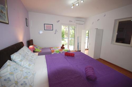 a bedroom with a large purple bed with a purple blanket at Apartment Mlađan in Njivice