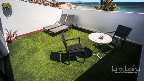 two chairs and a table on a balcony with the beach at La Cabaña in Peñíscola