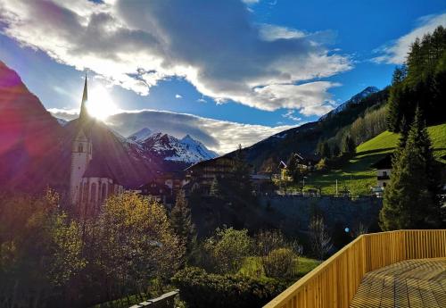 a view of a mountain range with the sun shining at Hotel Rupertihaus in Heiligenblut