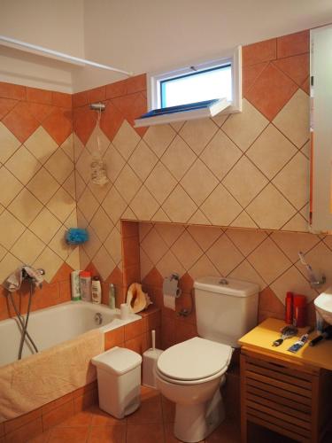 a bathroom with a toilet and a tub and a sink at Villa Natasa in Batsi