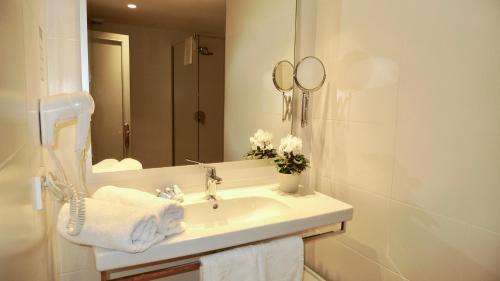 ein weißes Badezimmer mit einem Waschbecken und einem Spiegel in der Unterkunft Carabela in Paguera