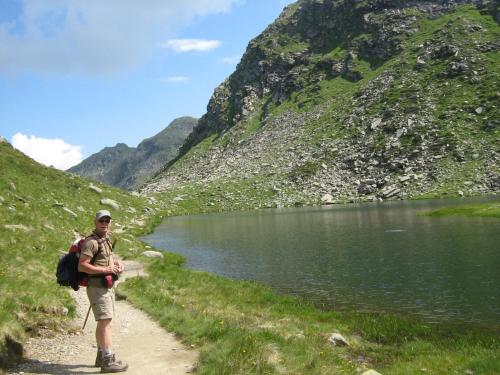 a man standing on a path next to a lake at Pitterle Hof in Meltina