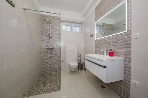 a bathroom with a toilet and a sink and a shower at Apartman Sunce in Ka&scaron;tela