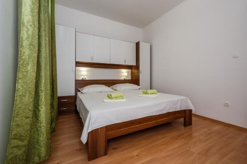 a bedroom with a bed with two towels on it at Apartman Sunce in Ka&scaron;tela