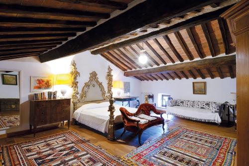 1 dormitorio con cama, silla y espejo en Castello Di Potentino en Seggiano