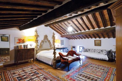 セッジャーノにあるCastello Di Potentinoのベッドルーム1室(ベッド1台、椅子、鏡付)
