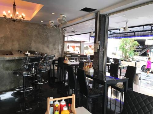 a restaurant with black tables and chairs and a bar at You Place in Pattaya