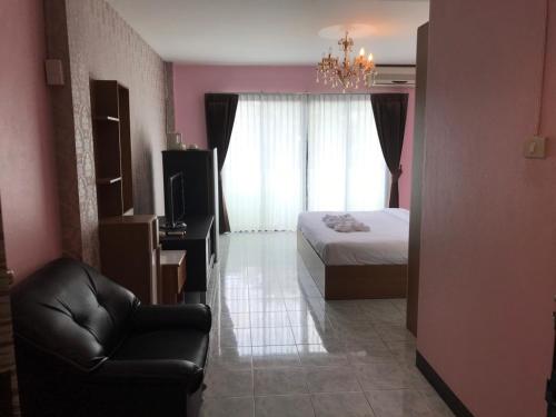 a bedroom with a bed and a chair and a couch at You Place in Pattaya