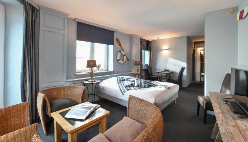 a hotel room with a bed and a table and chairs at Residentie De Laurier in Knokke-Heist